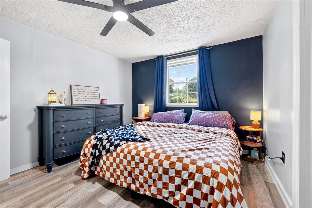 810 Edna Street Athens, TX 75751 - Photo 17 of 28 Bedroom featuring wood-finish flooring, a ceiling fan with integrated lighting, and a window with natural light