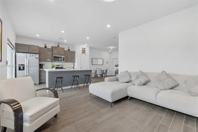 a living room with furniture and kitchen view