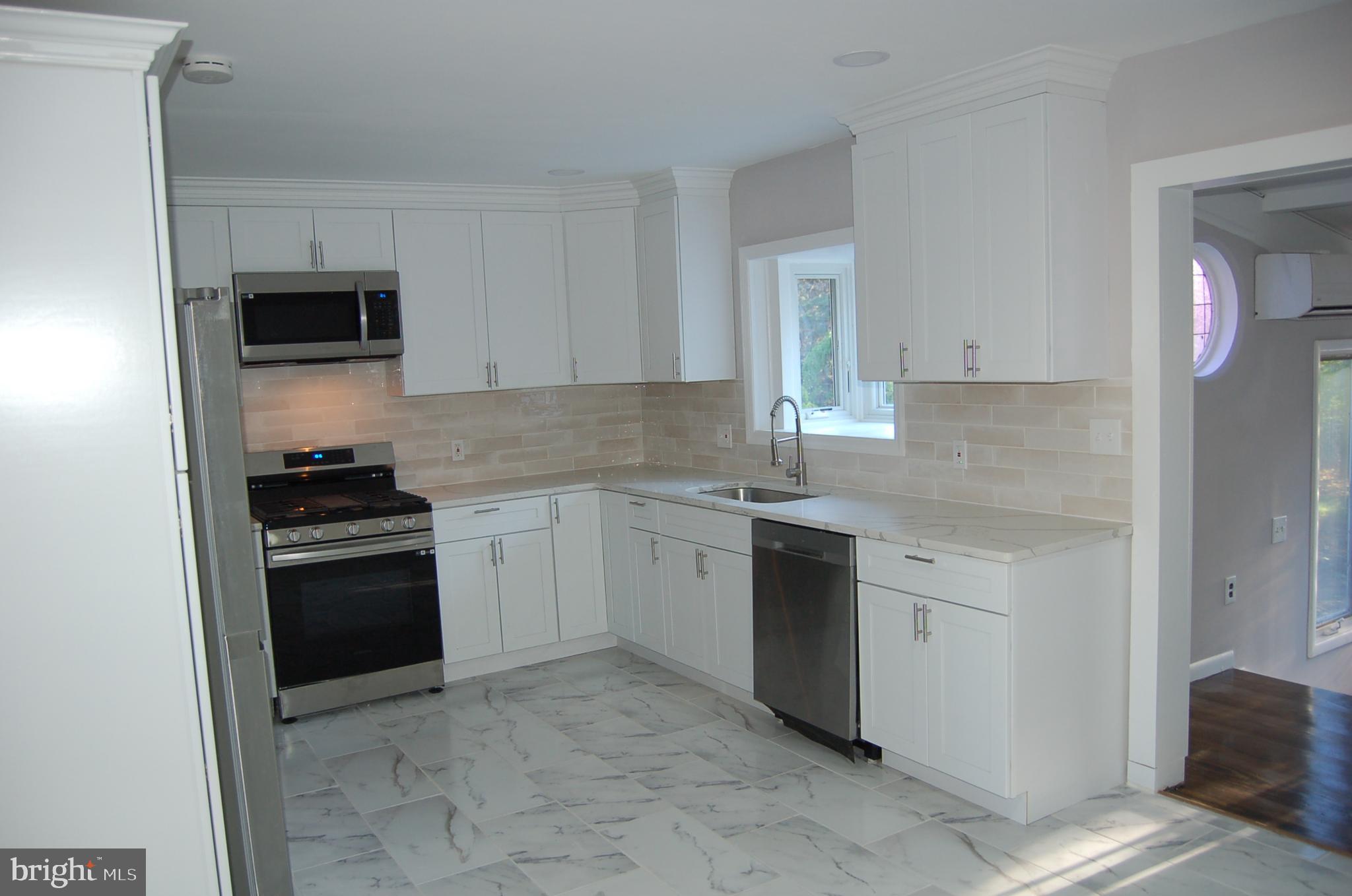 1482 Huron Road North Brunswick, NJ 08902 - Photo 13 of 17 a kitchen with granite countertop white cabinets and stainless steel appliances