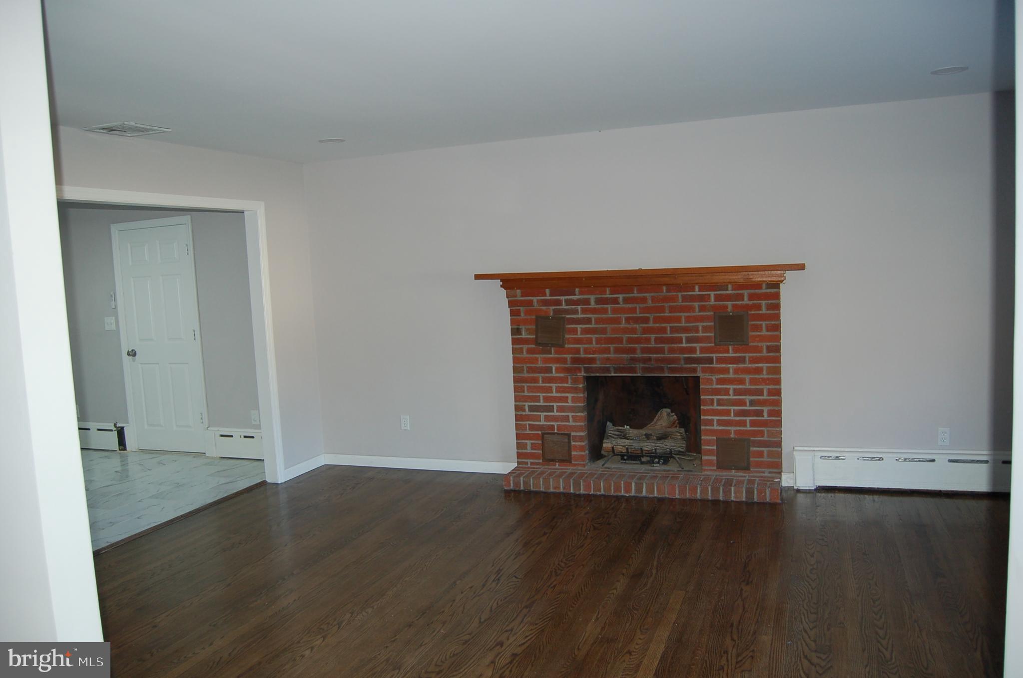 1482 Huron Road North Brunswick, NJ 08902 - Photo 15 of 17 an empty room with wooden floor and fireplace