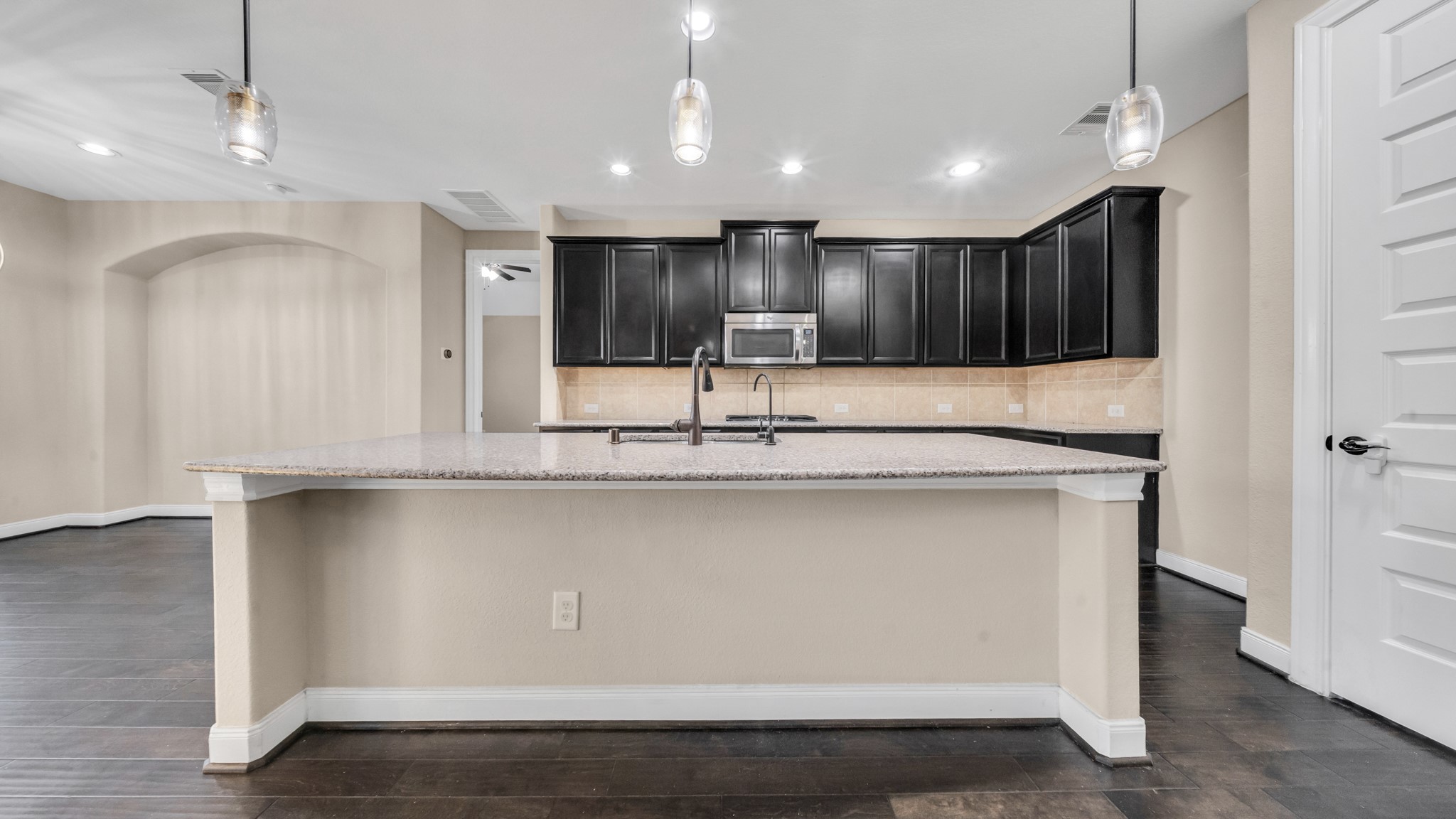 18118 Berry Garden Lane Spring, TX 77379 - Photo 13 of 45 Gourmet kitchen with granite countertops, dark cabinetry, stainless steel appliances, and a large island overlooking the living room.