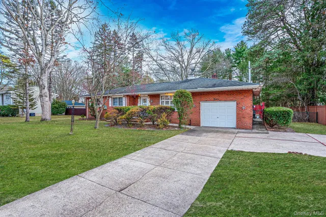 a front view of a house with a yard and trees