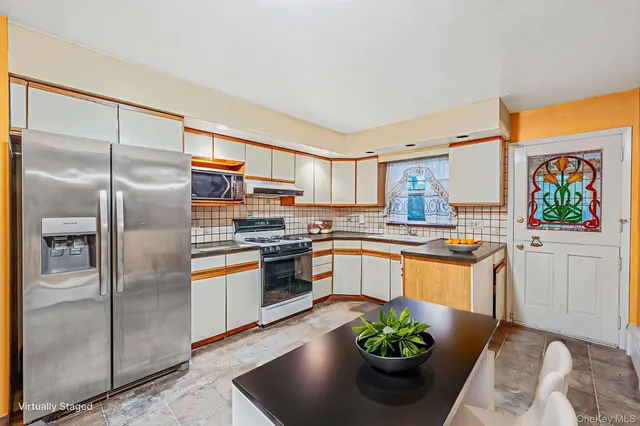 a kitchen with stainless steel appliances granite countertop a refrigerator a stove and a sink