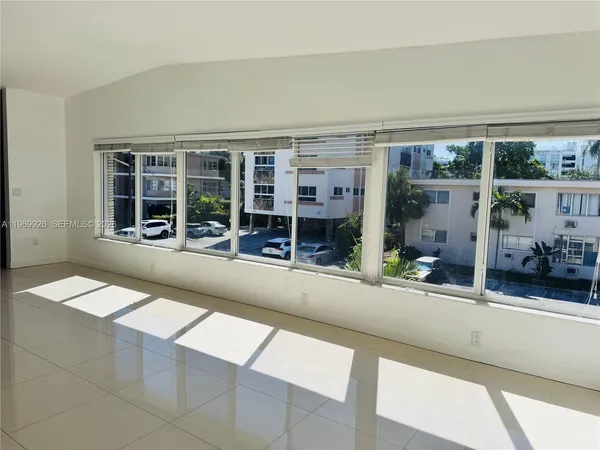 a living room with a large window and furniture