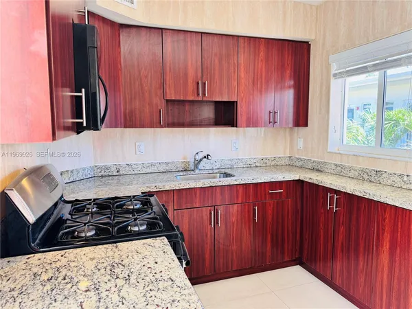 a kitchen with wooden cabinets and a stove top oven