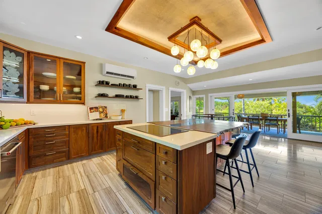 a kitchen with a stove a sink a dining table and chairs with wooden floor