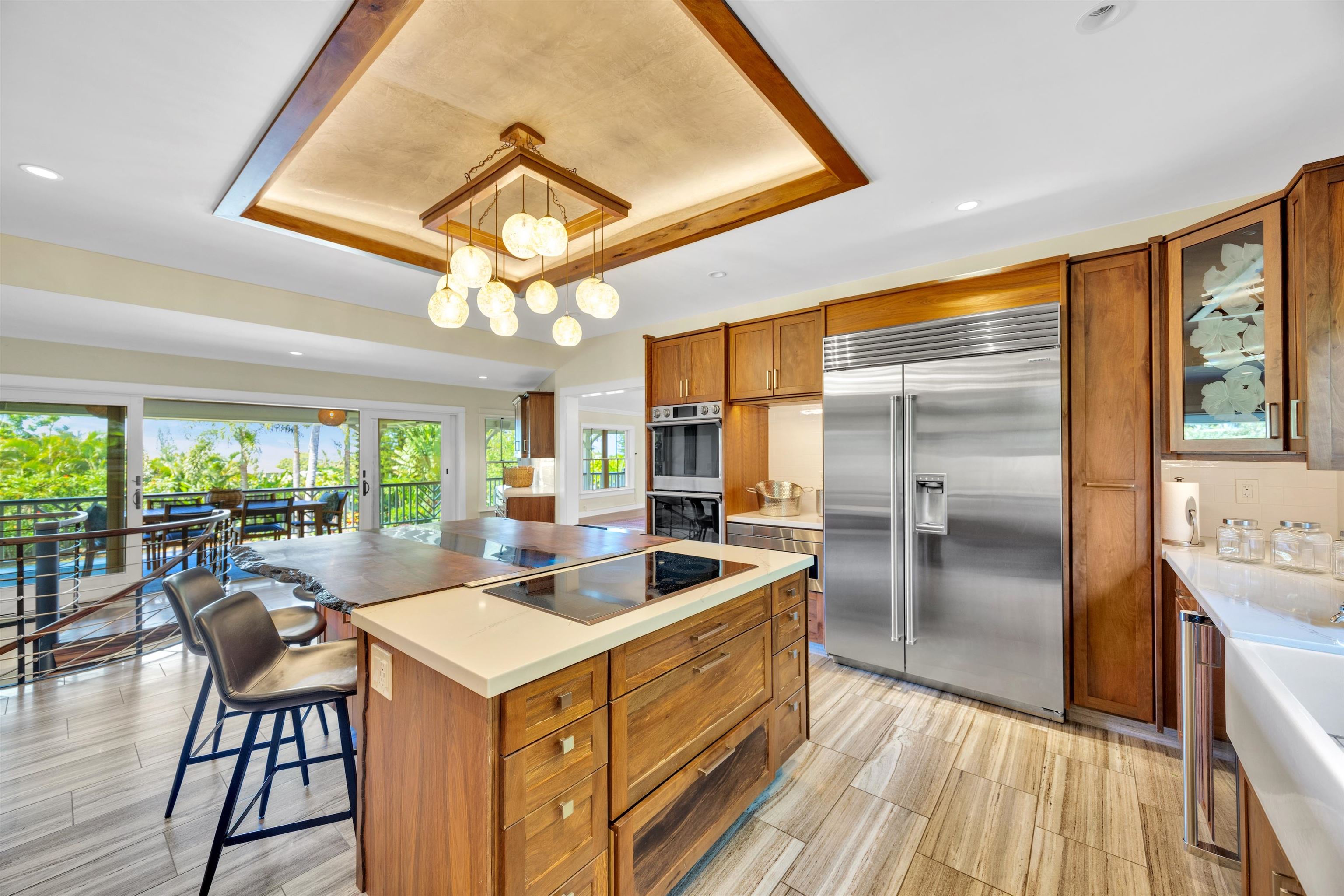 65 North Holokai Road Haiku, HI 96708 - Photo 14 of 50 a kitchen with a refrigerator a sink dishwasher a stove and a dining table with wooden floor