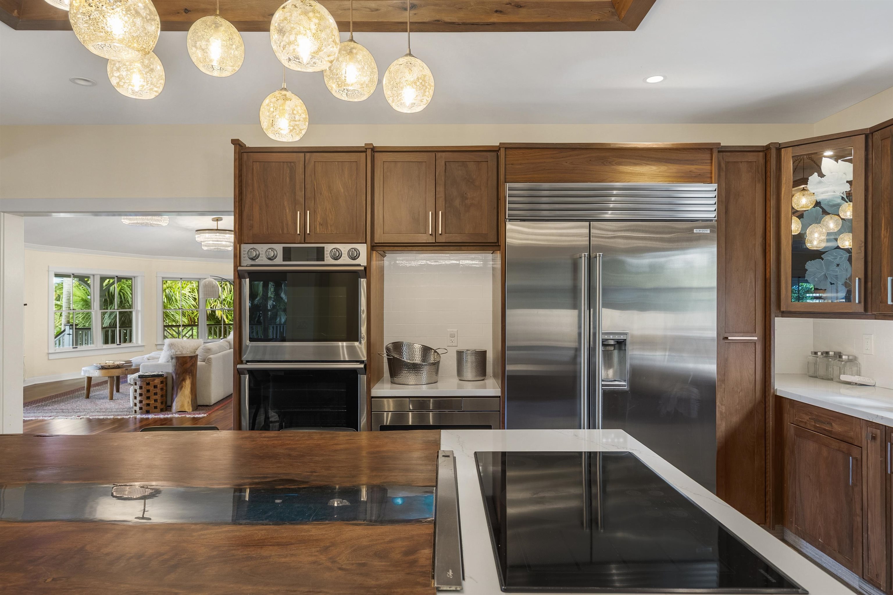 65 North Holokai Road Haiku, HI 96708 - Photo 14 of 50 a kitchen with kitchen island granite countertop a refrigerator a stove and a sink with wooden floor