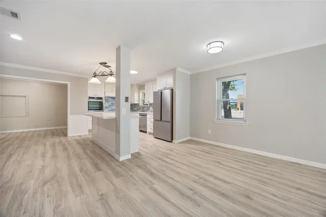 a view of a kitchen with a refrigerator and a stove top oven