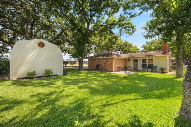 a front view of house with a garden and trees