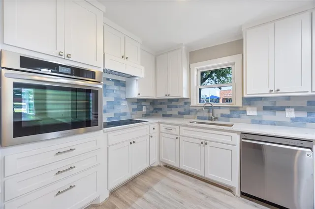 a kitchen with granite countertop white cabinets and white appliances