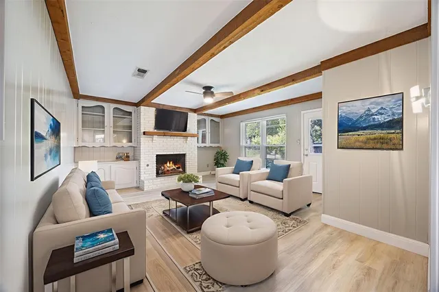 a living room with furniture a fireplace and a large window