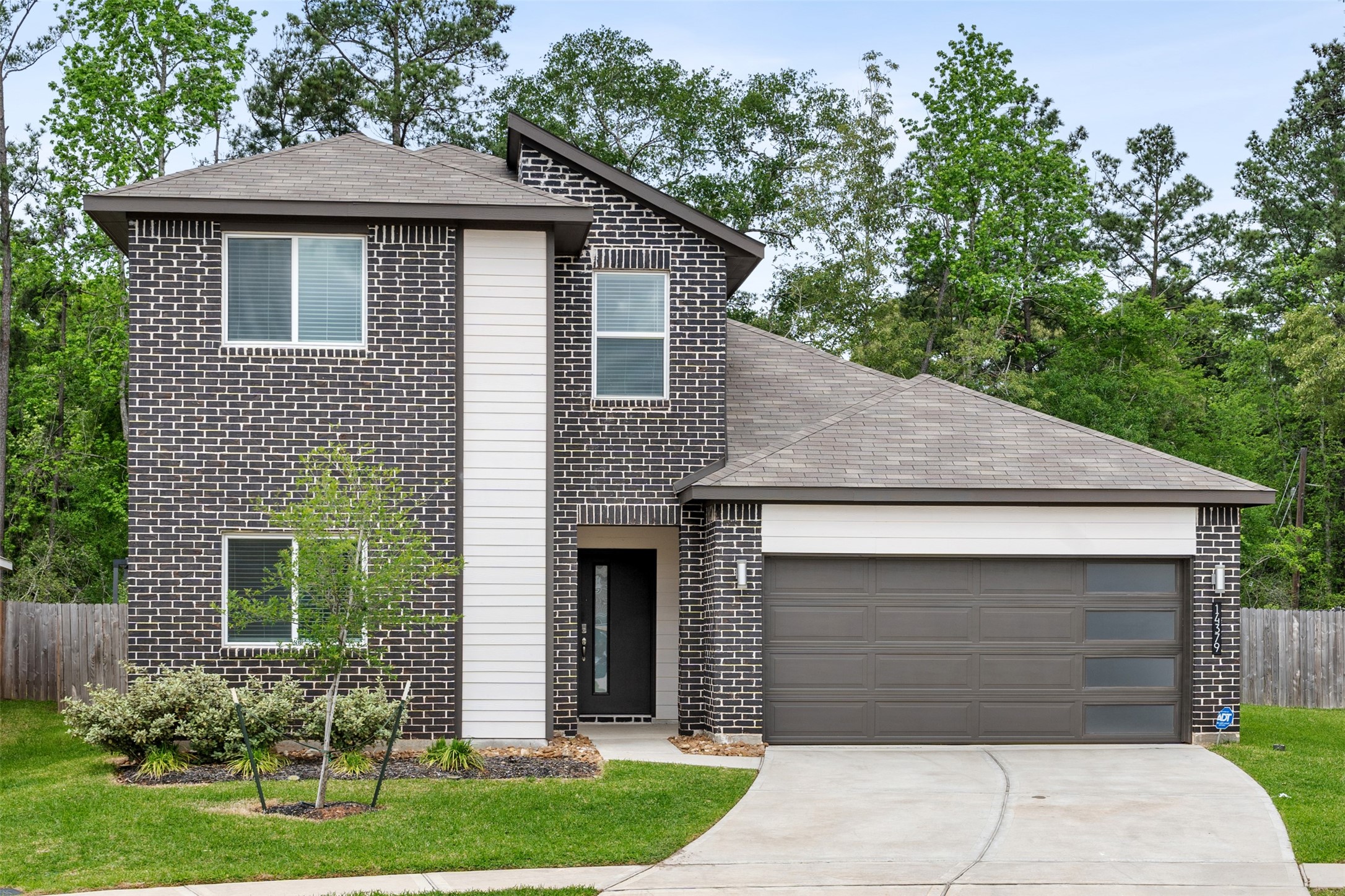 14379 Sweet Mdw Trail Conroe, TX 77384 - Photo 26 of 33 a front view of a house with a yard and garage