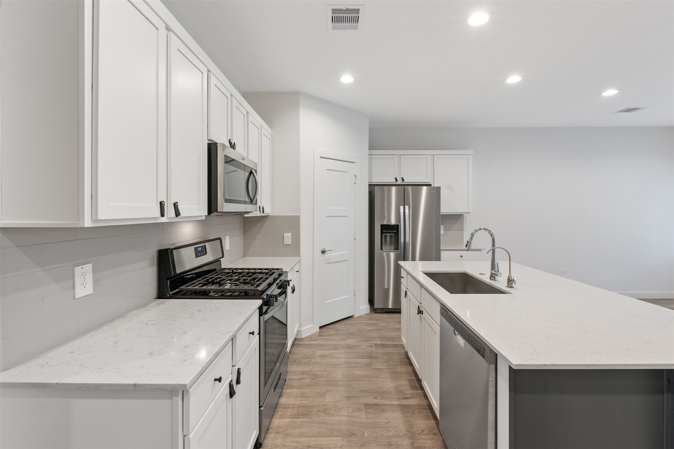14379 Sweet Mdw Trail Conroe, TX 77384 - Photo 4 of 33 a kitchen with stainless steel appliances a sink stove and refrigerator