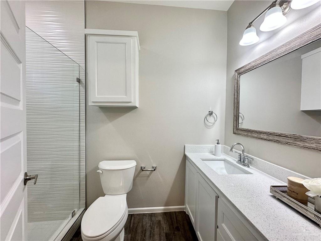 1011 Starr Street Mercedes, TX 78570 - Photo 16 of 35 a bathroom with a granite countertop toilet sink and mirror