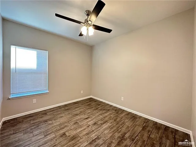 en empty room with wooden floor and windows