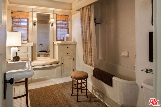 a bedroom with a bed a flat screen tv and a large window