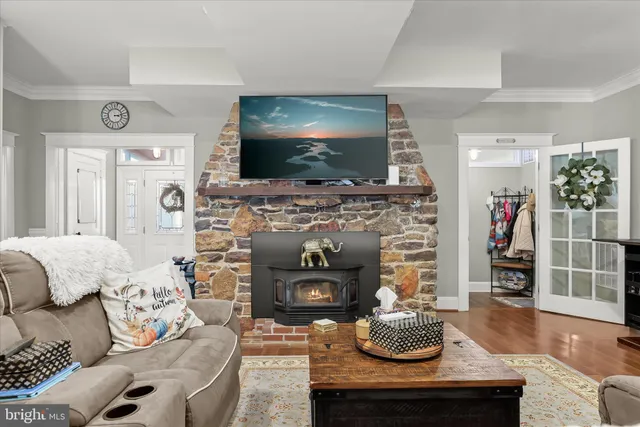 a kitchen with stainless steel appliances granite countertop a stove top oven a sink dishwasher and white cabinets with wooden floor