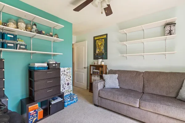 a living room with furniture and a shelf