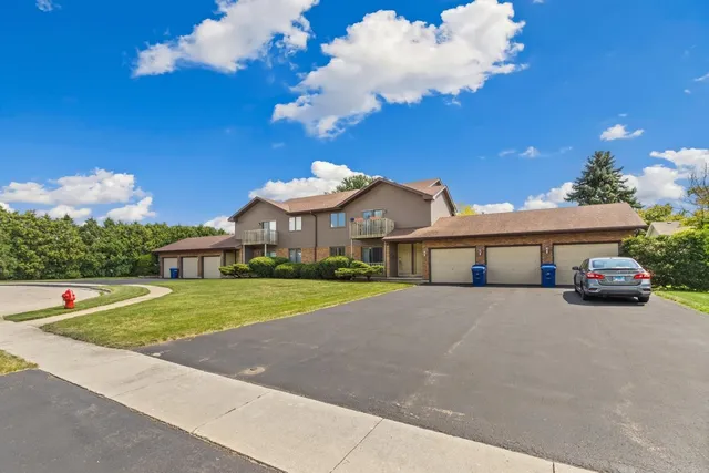 a view of a house with a yard and potted plants
