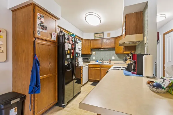 a kitchen with stainless steel appliances granite countertop a refrigerator a stove and a sink with cabinets