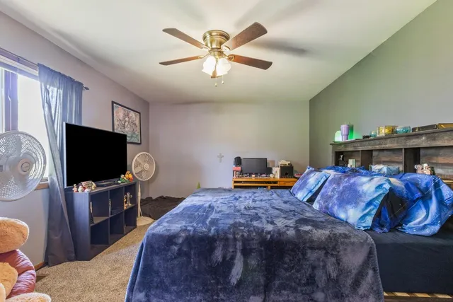 a bedroom with furniture and a flat screen tv