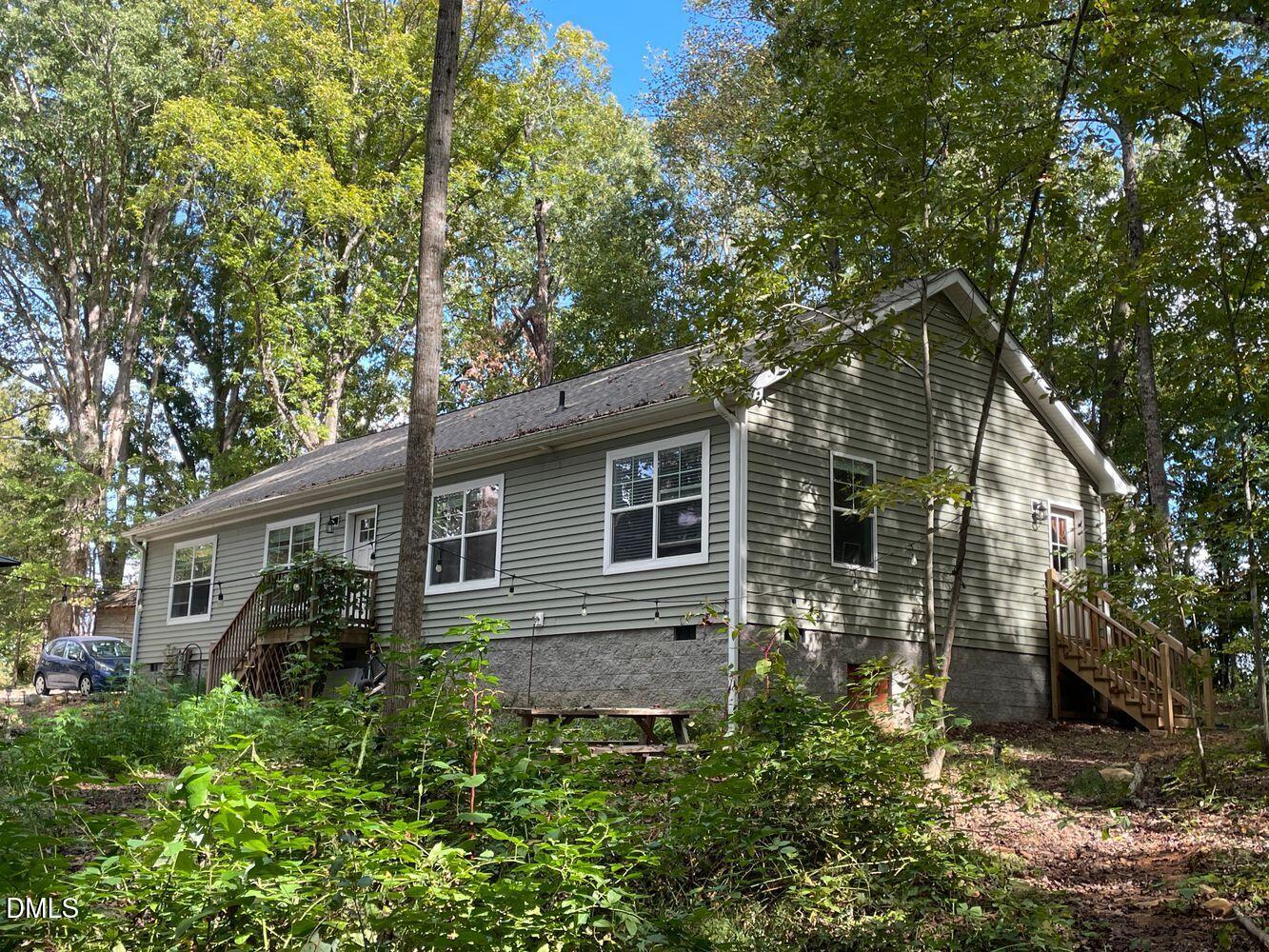 1500 McDade Store Road Cedar Grove, NC 27231 - Photo 1 of 1 a backyard of a house with plants and large tree