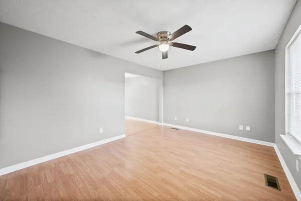 a view of an empty room with wooden floor
