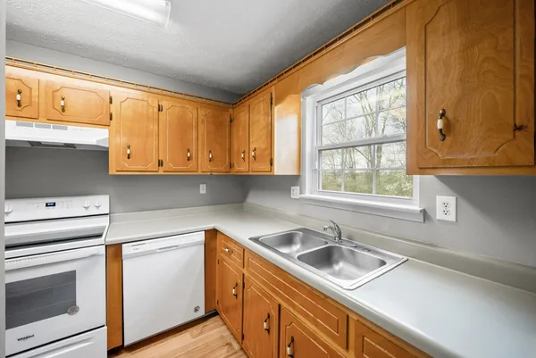 a kitchen with stainless steel appliances white cabinets a sink and a stove