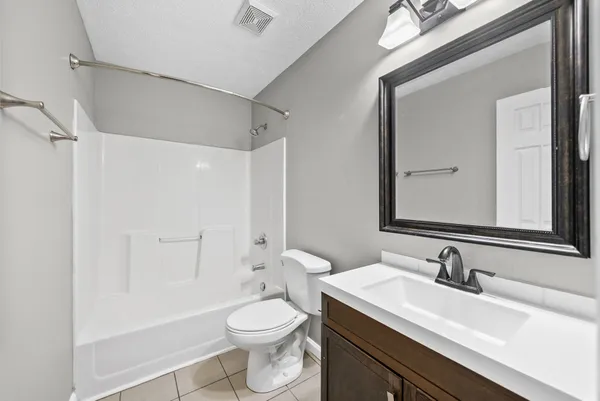 a bathroom with a sink a toilet and a large mirror