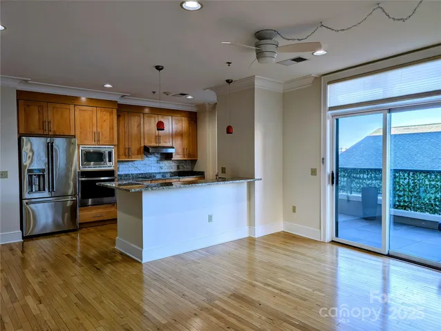 a kitchen with granite countertop a refrigerator and wooden cabinets
