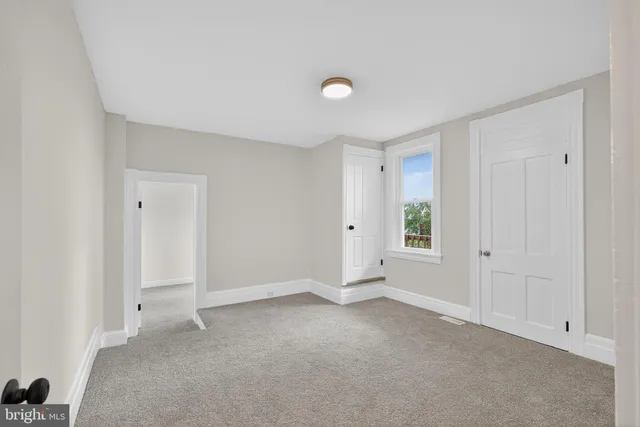 an empty room with windows and closet