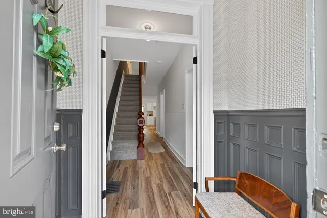 a view of a hallway with wooden floor and stairs