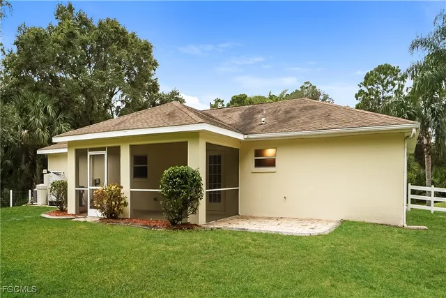 a backyard of a house with table and chairs