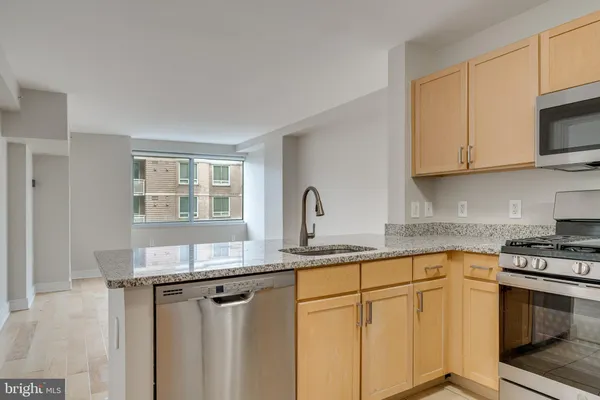 a kitchen with granite countertop white cabinets and white appliances