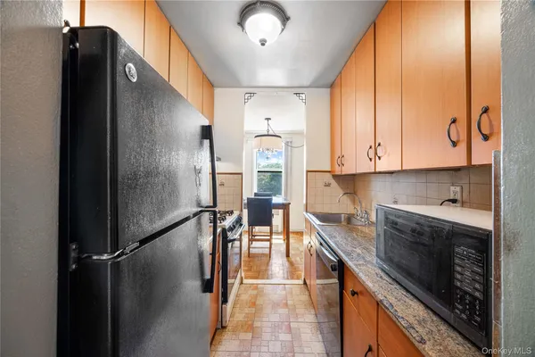 a kitchen with stainless steel appliances granite countertop a refrigerator a stove and a sink with granite countertops