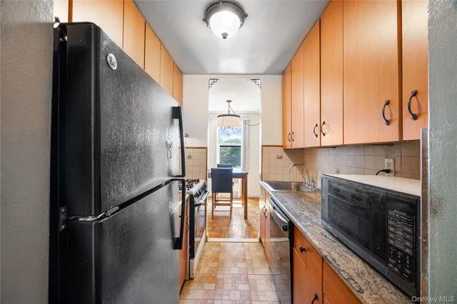 a kitchen with stainless steel appliances granite countertop a refrigerator a stove and a sink with granite countertops