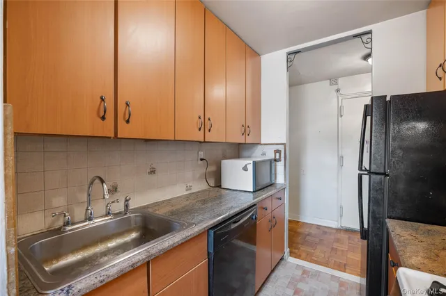 a kitchen with stainless steel appliances granite countertop a sink a refrigerator and a granite counter tops