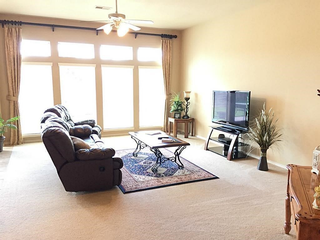 1602 Eden Meadows Drive Spring, TX 77386 - Photo 12 of 25 a living room with furniture a flat screen tv and a large window