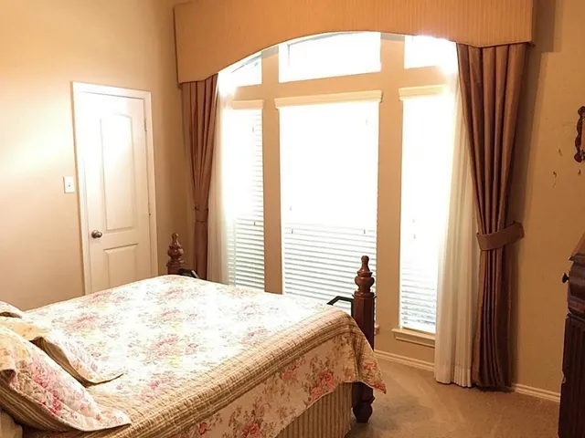 a bedroom with a bed and a window