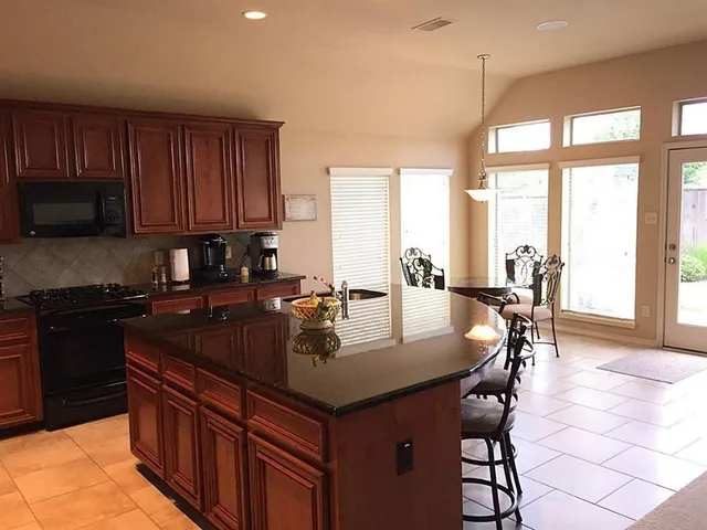 a kitchen with a stove a sink a dining table and chairs