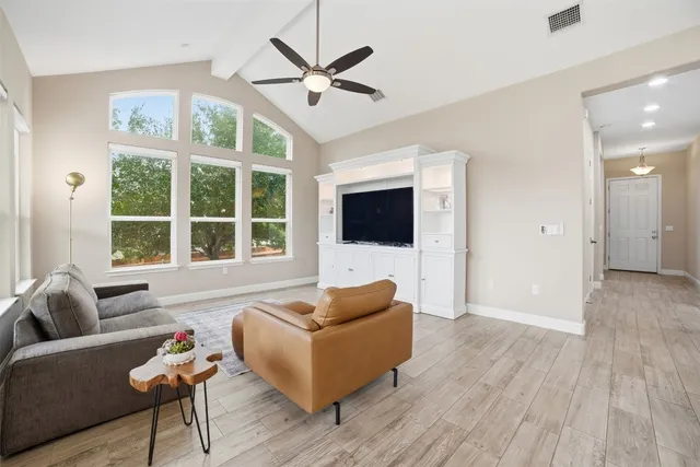 a living room with furniture ceiling fan and a flat screen tv