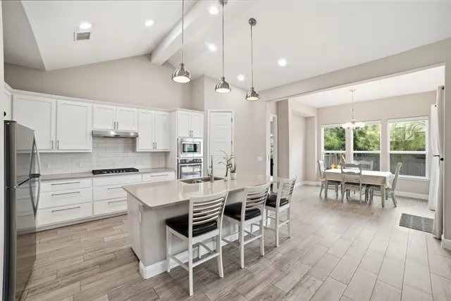 a large white kitchen with a large window