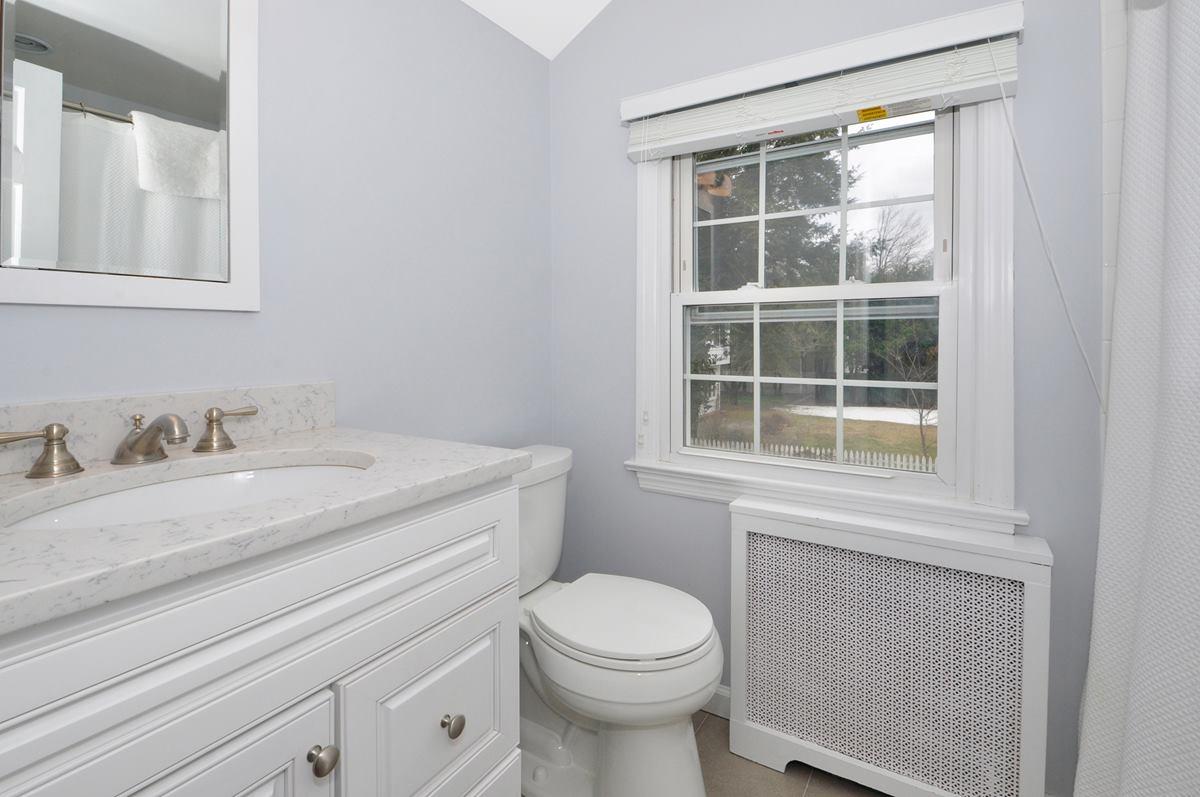 112 Hollow Tree Ridge Road Darien, CT 06820 - Photo 18 of 27 a bathroom with a granite countertop toilet sink and mirror