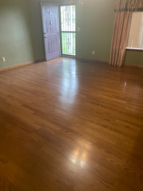 108 Bud Taylor Road Ethridge, TN 38456 - Photo 19 of 28 an empty room with wooden floor and windows with curtains