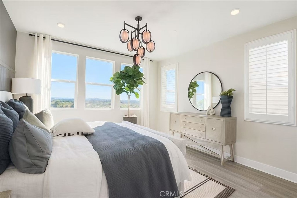 609 Gadwall Irvine, CA 92618 - Photo 7 of 10 a bed room with a bed a chandelier and a window
