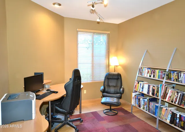 a view of a workspace with furniture and a bookshelf