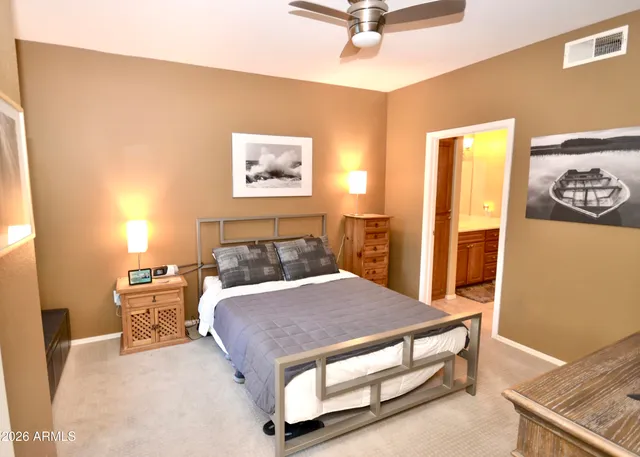 a bedroom with a bed and painting on the wall