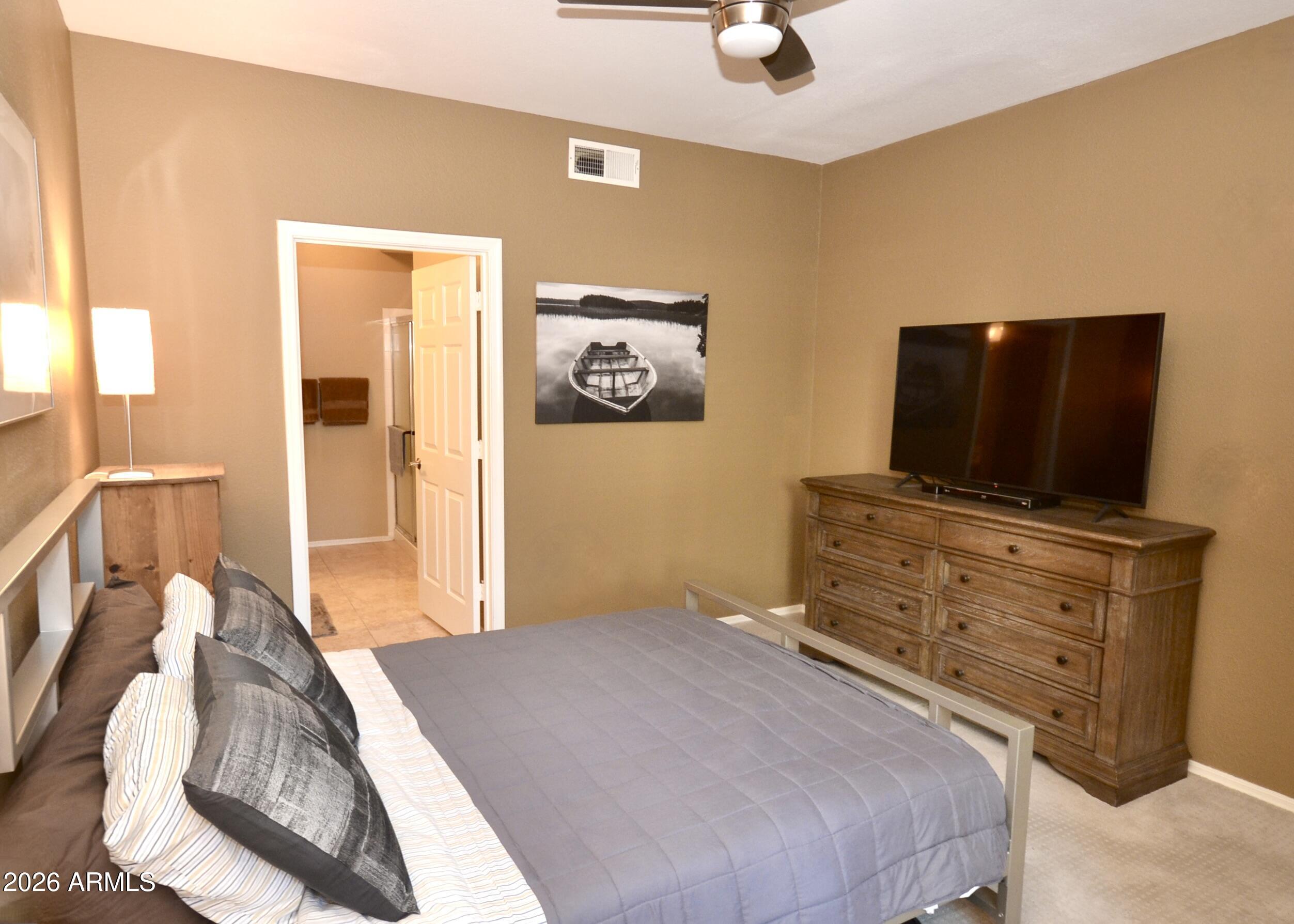 5303 North 7th Street, Unit 117 Phoenix, AZ 85014 - Photo 18 of 31 a bedroom with a bed and flat screen tv