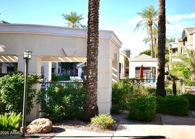 a front view of a house with a yard and potted plants